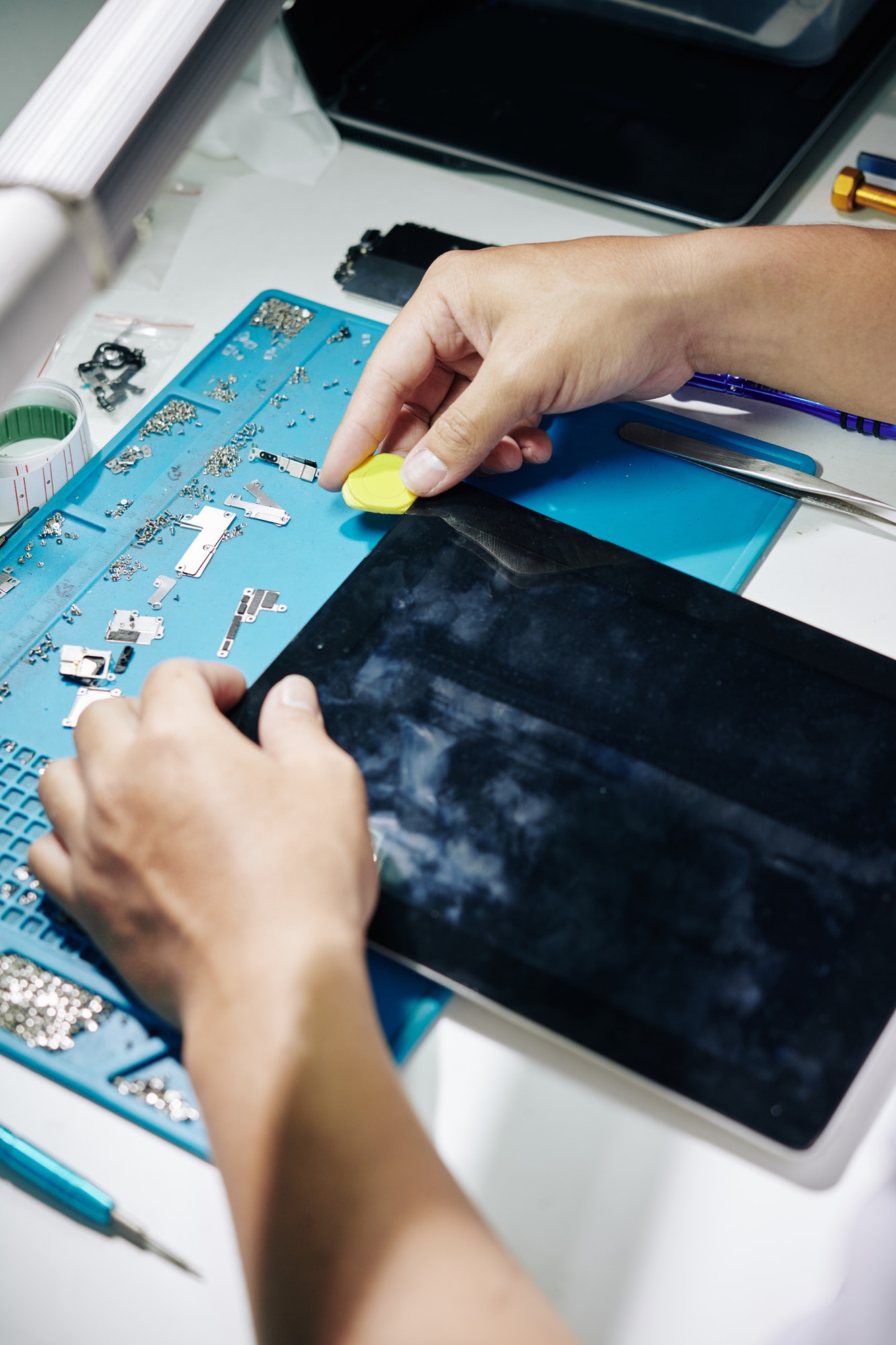 Repairman removing screen of tablet computer